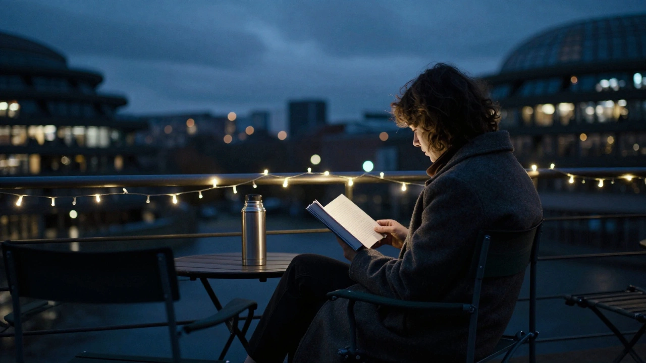 A solitary reader on a terrace at night with a thermos and book, stars visible above the city skyline.